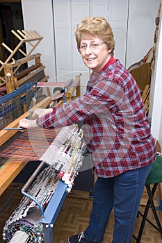 Senior Woman Weaving on Loom, Textile Artist photo