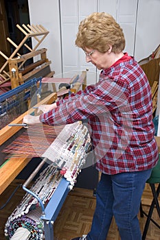 Senior Woman Weaving On Loom, Textile Artist photo