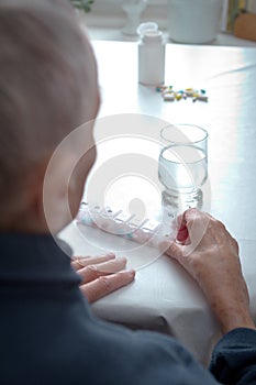 Senior woman weekly pill dispenser GERMAN