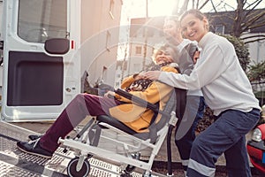 Senior woman in wheelchair being picked up by transport service