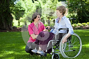 Senior woman on wheelchair with caring caregiver