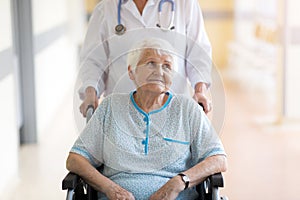 Senior woman in wheelchair with female doctor in hospital