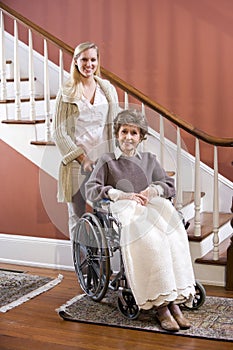 Senior woman in wheelchair at home with nurse