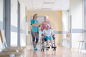 Senior woman in wheelchair with nurse in hospital