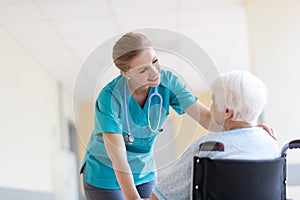 Senior woman in wheelchair with nurse in hospital