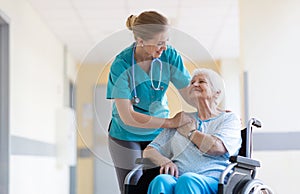 Senior woman in wheelchair with nurse in hospital