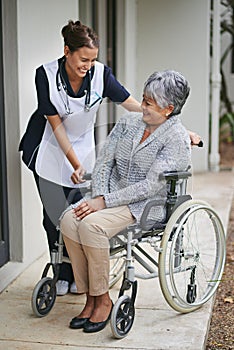 Senior woman and wheelchair at nursing home with nurse for assistance with disability, help at clinic. Disabled patient