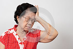 A senior woman who has a severe headache suffers from a stroke ,brain disease,patient holding head with her hand,suffering from