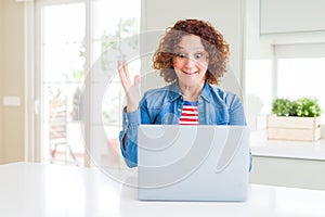Senior woman working using computer laptop very happy and excited, winner expression celebrating victory screaming with big smile