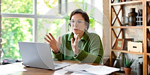 A senior woman works in front of a laptop monitor. Consulting on online filling of tax forms and documents. Forman photo photo