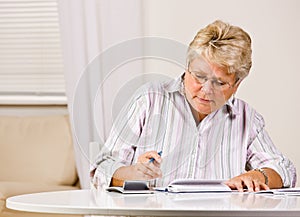 Senior woman writing checks