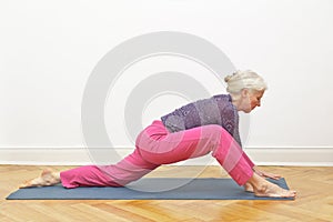 Senior woman yoga exercise dragon