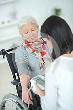 senior woman with young doctor having medical care at home