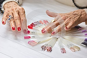 Senior womans hands with red manicure.