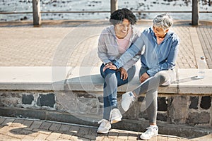 Senior women, bench sitting and beach with friends, training and laugh in summer outdoor. Exercise, break and mature