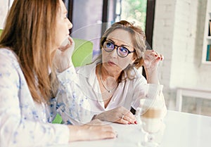 Senior women close friends sitting in cafe bar or restaurant  enjoying in conversation