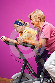 Senior women doing spinning in gym