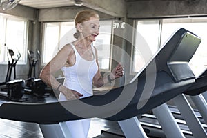 Senior women exercise jogging at gym fitness smiling and happy. elderly healthy lifestyle
