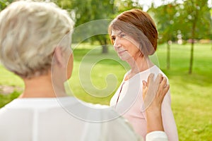 Senior women or friends talking at summer park