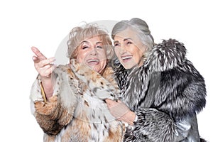 Senior women in fur coats looking at something