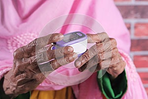 Senior women hand using pulse oximeter photo