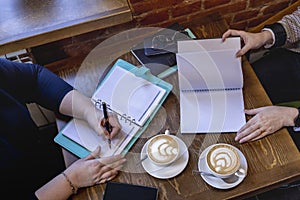 Senior women hands write in notebook. Flat lay. View from above. Diversity people