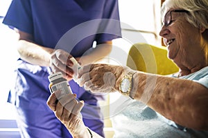 Senior woman taking medicine from the nurse photo