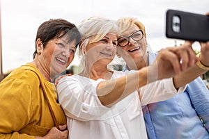 Senior women using mobile phone together