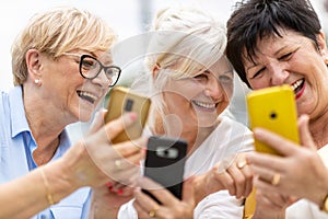 Senior women using mobile phones together