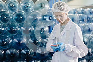 Senior women worker work in drink water factory counting check water bottle gallon stock in hygiene uniform workplace