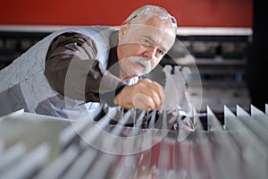 Senior worker checking sheets metal photo