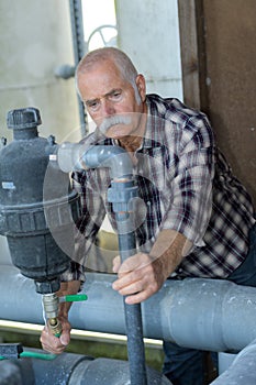 senior worker checks bent metal rods