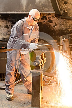 senior worker cutting metal