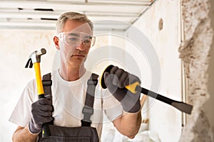 Senior worker demolish wall