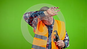 Senior worker plumber wiping forehead with hand after tiring work.