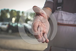 Senior worker provides hand. Close up.