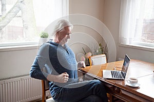Senior working on computer having low back pain photo