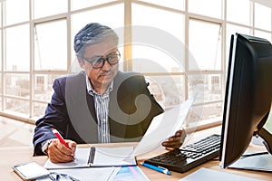 senior working man reading business paper report on working table use for people in office life