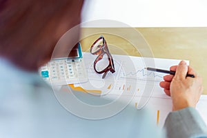 senior working woman holding pencil with eyeglasses, calculator