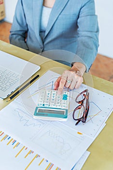 senior working woman touching calculator with eyeglasses and rep