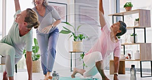 Senior yoga instructor teaching beginner poses to mature women in her exercise class. Fit ladies practicing yoga with