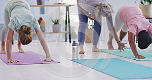 Senior yoga instructor teaching yoga pose to mature women in her exercise class. Active ladies practicing pilates with