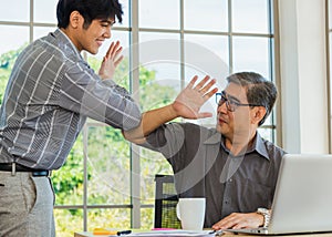 Senior and young business man greeting