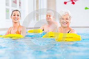 Senior and young people in water gymnastics