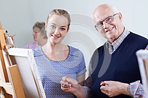 Seniors Attending Painting Class With Teacher