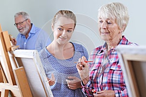 Seniors Attending Painting Class With Teacher