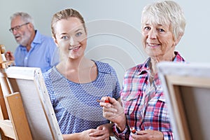 Seniors Attending Painting Class With Teacher