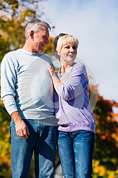 Seniors in autumn or fall walking hand in hand