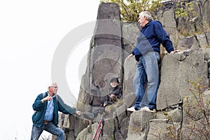 Seniors and child trekking on the rock