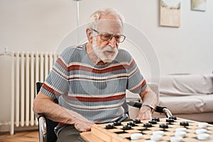 Seniors couple playing checkers at nurse home together